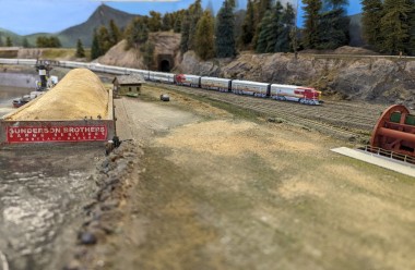 A Santa Fe "Super Chief" passenger train passing by a wood chip facility