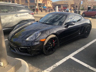 Picture of a black Porsche Carrera in a parking lot
