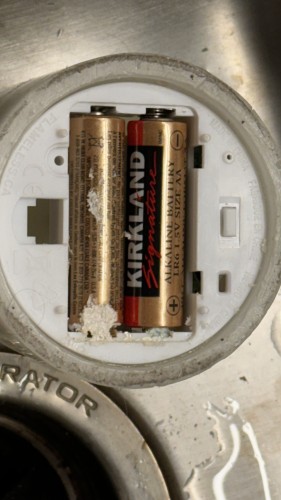 Four year-old batteries found in a forgotten battery powered candle. The batteries show a white crust indicating that the batteries have burst, and the metal is slightly corroded.