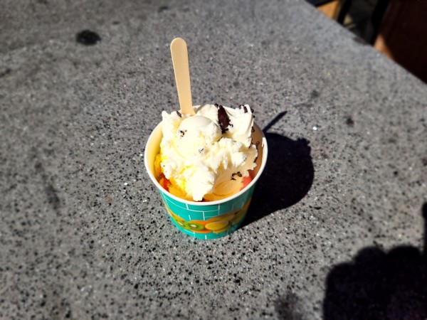 Cup of ice cream, in the sunshine, on a grey table