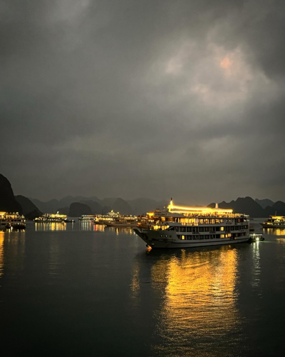 Night view of Halong Bay, ships light up the sky. 