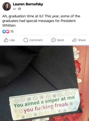 Image is of a social media post by Lauren Bernofsky, wherein she says "Ah, graduation time at IU! This year, some of the graduates had special messages for President Whitten." 

The post refers to an attached photo of a student's mortar board with a happy celebratory sticker on it that says "You aimed a sniper at me you fucking freak." 