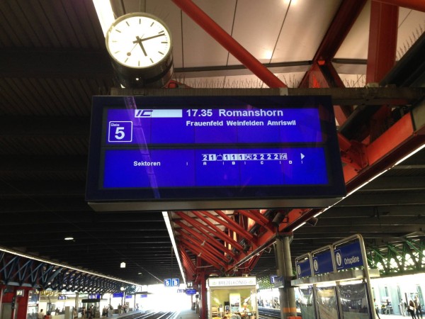Blue and while LCD showing departure information in a railway station, consisting of a number of square panels of about 120×120 pixels.