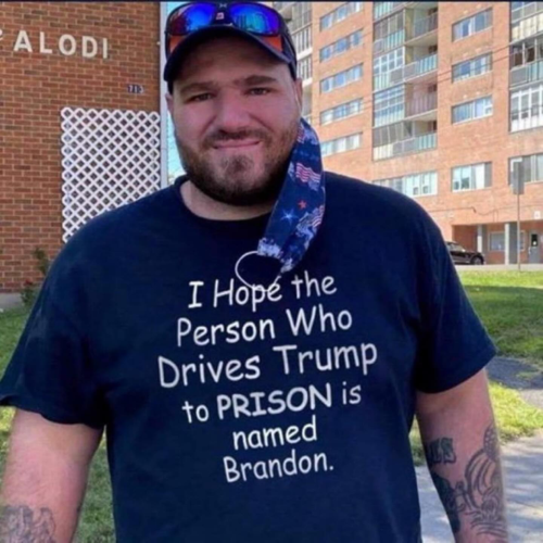 Man wearing a t-shirt that says, "I Hope the Person Who Drives Trump to PRISON is named Brandon"