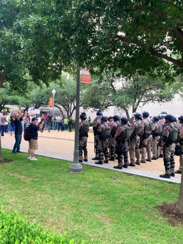 Rows of Texas State Troopers preventing students from getting to the far side of their campus.