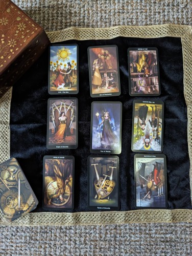 Picture of 9 SteamPunk tarot cards in no particular order, the cloth on which they are spread, and the box in which they reside.