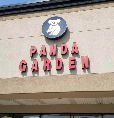 Signage for "PANDA GARDEN" with a round logo featuring a stylized koala above the text on a building facade.