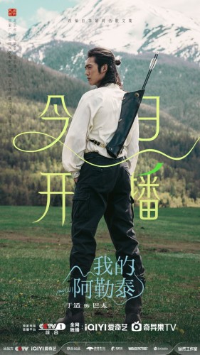 Yu Shi standing with his back to the camera in a white shirt and dark green trouser. He has a shiver of arrows on his back. The backdrop is a mountain scene.