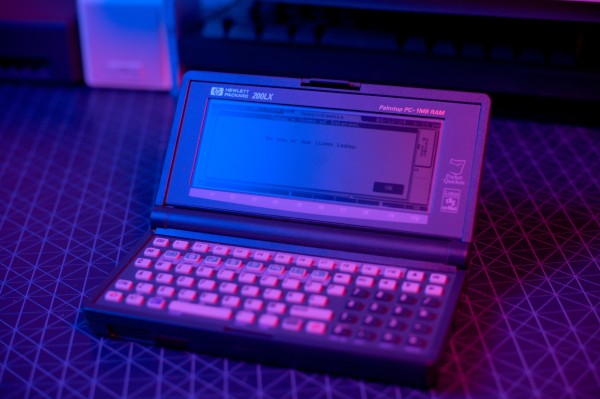 An HP 200LX, opened, looking at the Agenda application. The photograph is taken in moody bisexual lighting.