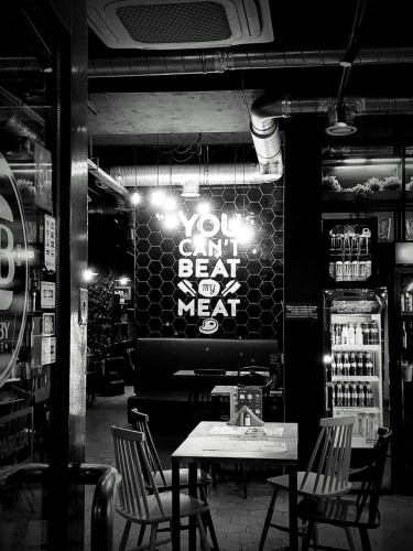 View into burger restaurant, focusing on Wall decoration: "you can't beat my meat"