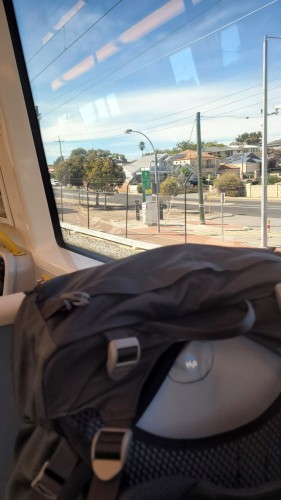 Looking over the top of my pack out the train window at suburbia 