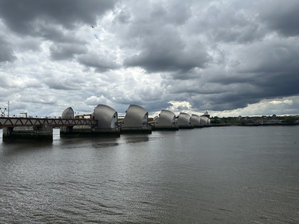 The Thames barrier, as seen from the north bank. There are dark clouds in the sky