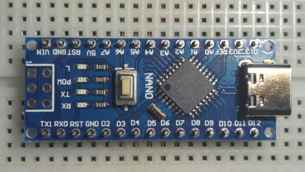 Arduino Nano microcontroller board sitting on a breadboard, unsoldered.
