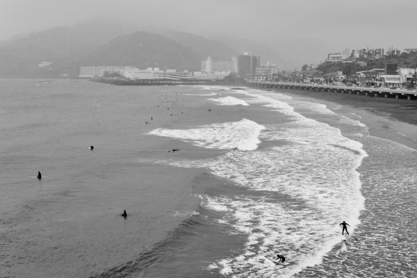 Ein größere Anzahl von Surfern bei regnerischem Wetter, schwarzweiß Bild; 
large number of surfer in misty weather in black and white picture