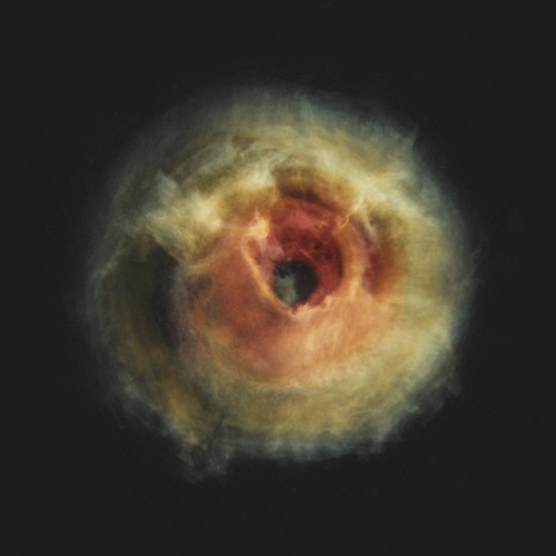 a fluffy, feathery, spherical structure that is redder in its center, expanding out into orange and yellow and eventually a pale gray. it is surrounded by the void. there's a dark, empty circle near the center. it is clearly a kind of nebula, but the sky is otherwise starless and empty