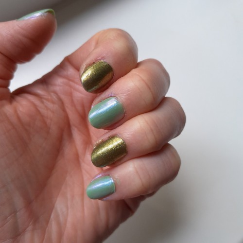 photo de mes ongles en couleurs alternée vert irisé bleuté et vert à paillettes dorée. 