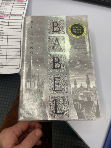 A photo of’Babel’ by RF Kuang with a library transfer label beside it 