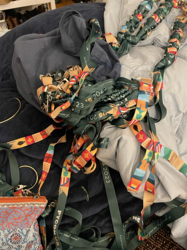A large tangle of PyCon US 2023 lanyards on a messy bed 