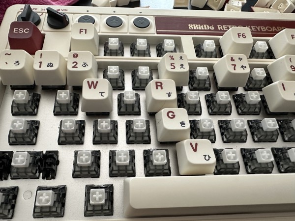 Zbliżenie klawiatury mechanicznej w stylu retro z częściowo zdjętymi nasadkami klawiszy, odsłaniającymi znajdujące się pod nimi przełączniki.
