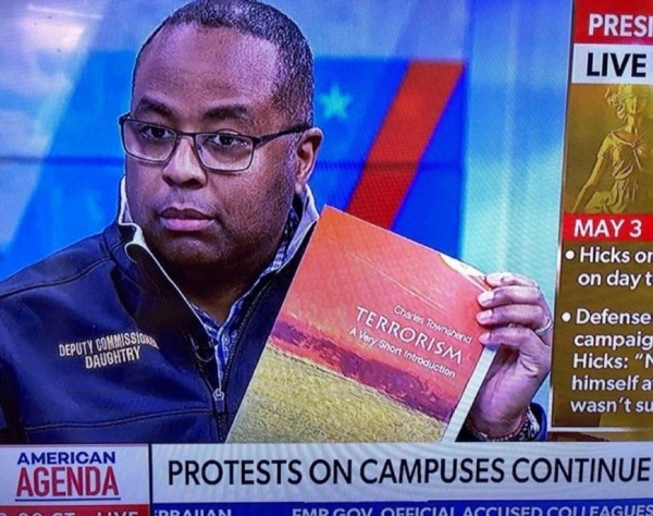 NYPD dude on TV holding up an academic book entitled “Terrorism” 