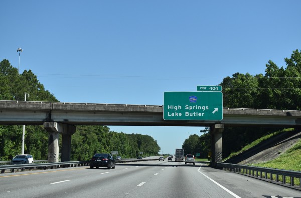 Someone driving on the highway - in front of them there's a sign for Exit 404 (towards High Springs and Lake Butler). Exit 404 is a website error shown when the page / resource can't be found
