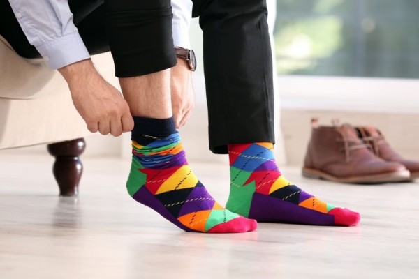 Une personne met ou ôte des chaussettes multicolores