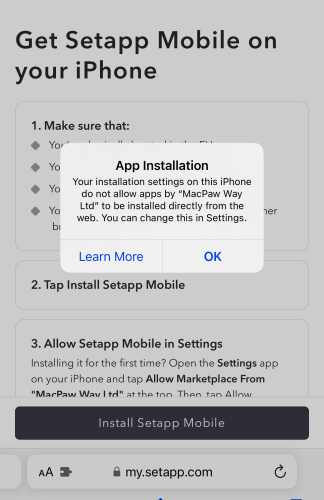 A smartphone screen displays instructions for installing Setapp Mobile with a pop-up saying apps by "MacPaw Way Ltd" can't be installed directly, prompting an OK button click. 
Text:
Get Setapp Mobile on your iPhone
1. Make sure that:
- You've installed apps with File Browser before
- ...
- ...
App Installation
Your installation settings on this iPhone do not allow apps by "MacPaw Way Ltd" to be installed directly from the web. You can change this in Settings.
Learn More     OK
2. Tap Install Setapp Mobile
3. Allow Setapp Mobile in Settings
Installing it for the first time? Open the Settings app on your iPhone and tap Allow Marketplace From "MacPaw Way Ltd" at the top. Then tap Allow
Install Setapp Mobile
AA     my.setapp.com