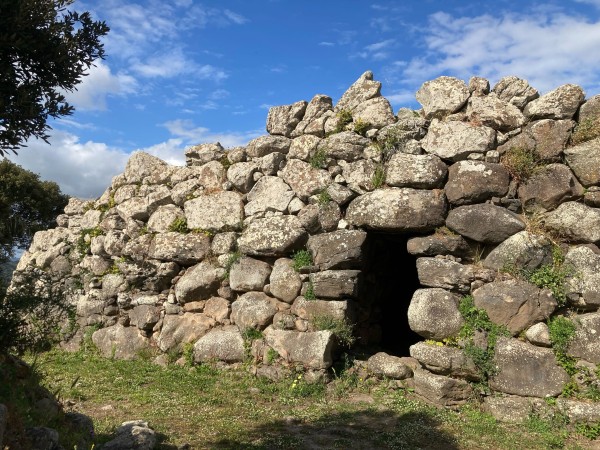 A structure made from huge basalt boulders with a small entrance. A huge rock forms the door lintel 
