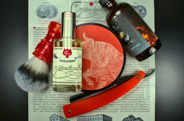 A bottle of Farina 1709 on a orange-themed set of of wetshaving gear