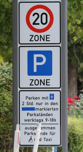 Verkehrschild mit 20 Zone, Parkzone, 2 Stunden Parken mit Parkscheibe in markierten Parkständen, ausgenommen Parkstände für Behinderte und Taxi. 