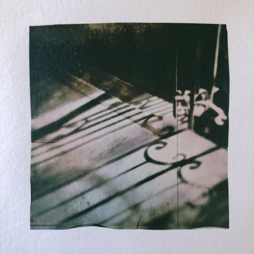 Shadows of a stair railings in an old building. Polaroid emulsion lift.