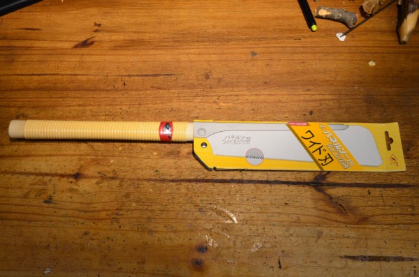A long-handled backsaw in its packaging. Texts in Japanese on it.