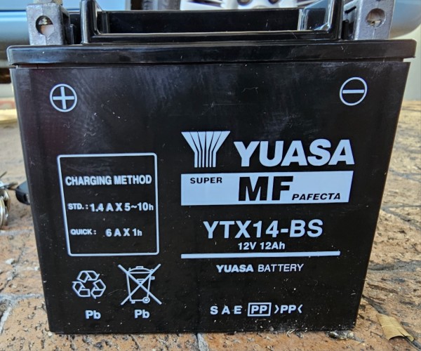 Yuasa YTX14-BS battery for bike standing on yellow brick paving