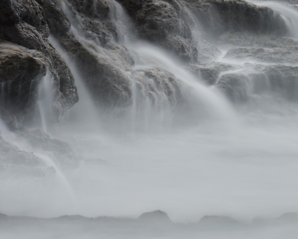 Long exposure picture of the sea flowing down the rocky beach at Roca Negra Tenerife so it looks like lots of waterfalls flowing down cliffs.