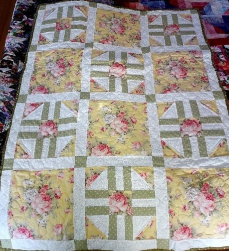a garden-themed quilt, alternating boxes, yellow with pink flowers, and pale green cross designs, 12 boxes total 