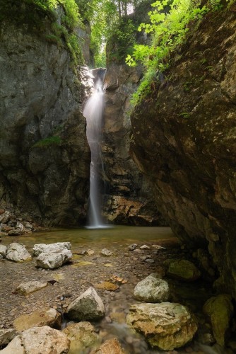 Eine Waldszenerie mit Wasserfall und Felsen