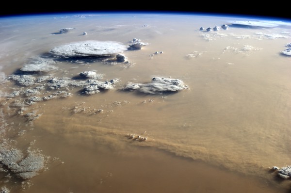  In the photo, winds appear to be coming out of the east or northeast (left), and the sun is setting to the west (right in this image). Billowing cumulus and cumulonimbus clouds suggest that a cold, windy front was moving across the desert, perhaps a haboob. The thick dust almost completely blocked the African land surface from view; even the lower portions of some clouds were obscured. 