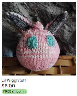 A roughly egg-shaped small knitted pink pokemon with rabbit-like ears and round blue eyes. Lil Wigglytuff $6 free shipping