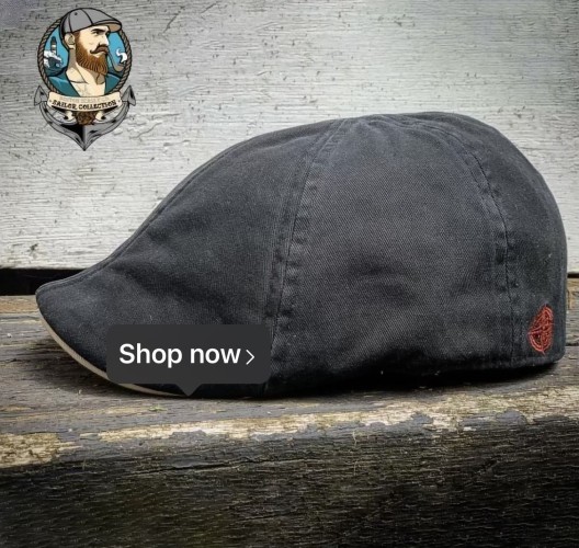 Photo of a British-style driving cap. It’s made of dark dyed cotton and literally looks like a baseball cap that hasn’t had a bris. 