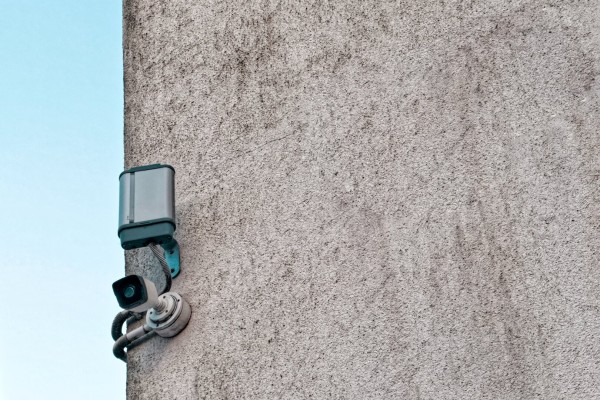 Surveillance camera on the corner of a wall.