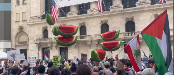 Large crowd with flags, placards and watermelon slice balloons