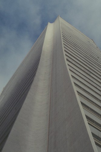 Low-angle shot of a concrete skyscraper pointing to the sky