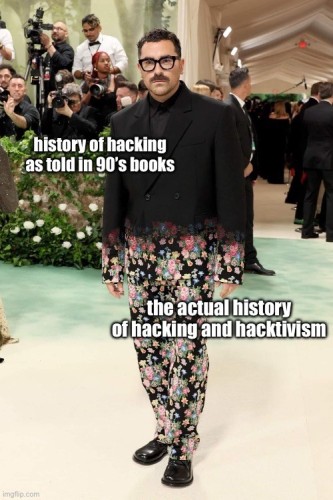 Met gala outfit worn by a man, the top half is monochrome black but fades into various colored floral pattern on the legs. The top is labelled “history of hacking as told in 90’s books”, while the bottom of the outfit it labelled “the actual history of hacking and hacktivism”