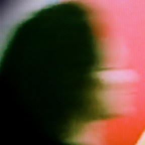 A blurry side view of a person's head as they are walking.