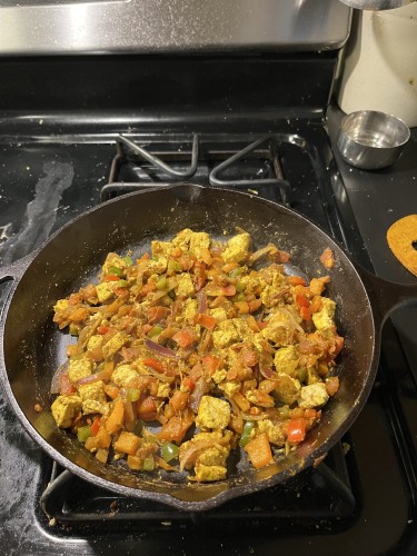 Homemade Paneer Khurchan in a cast iron skillet on a stove.