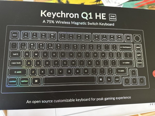 A black box with silver text and drawing of a keyboard. It reads:

Keychron Q1 HE

A 75% Wireless Magnetic Switch Keyboard

An open source customizable keyboard for peak gaming experience