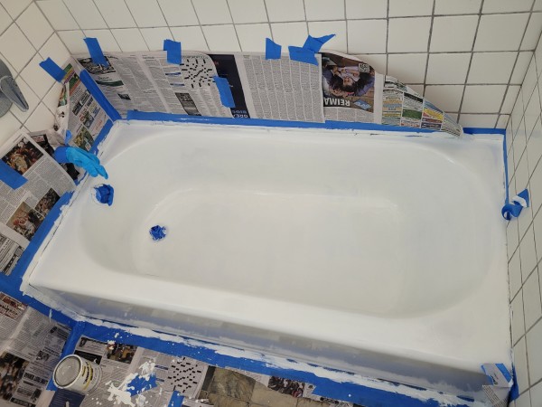 Bathtub, very white. Some of masking on sides removed, but only a tiny bit. Blue tape and newspaper everywhere.