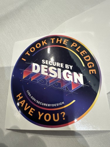 A sticker that says “I took the pledge, have you?” With a big logo that says “secure by design” and a URL: CISA.gov/securebydesign