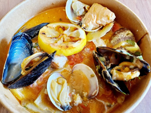 Bouillabaisse - local fishes, shellfish, tomato fennel broth, parsley, saffron aioli & fingerling potatoes with lemon slice - in takeout container.