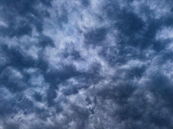 A contrast enhanced picture of a highly structured clouds seen from below. The picture has a grey-blue tint.